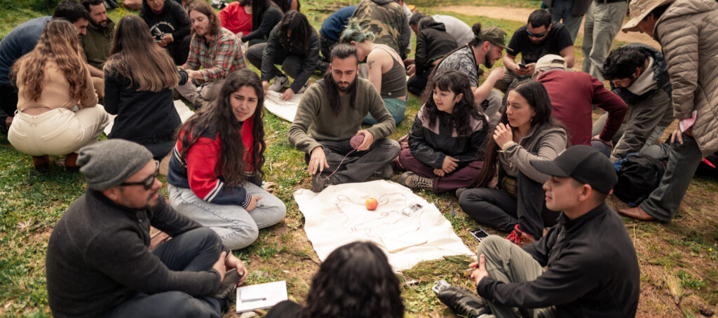 Personas haciendo mapas con telas y lanas al aire libre
